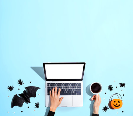 Halloween decorations with person using a laptop computerの写真素材