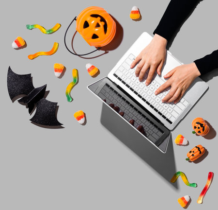 Halloween decorations with person using a laptop computerの写真素材