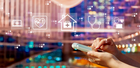 Telehealth theme with person using a smartphone in city at nightの写真素材