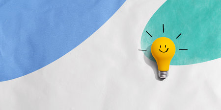 Yellow light bulb with happy faceの写真素材