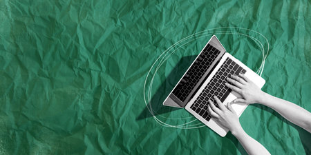 Person using a laptop computer with crumpled paper textureの写真素材
