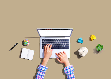 Laptop computer with a piggy bank and office objectsの写真素材