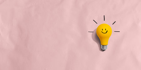 Yellow light bulb with happy faceの写真素材