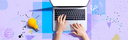 Person using a laptop computer and a light bulbの写真素材