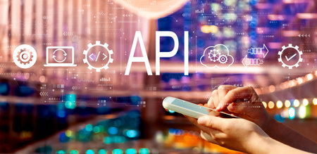 API - application programming interface concept with person using a smartphone in city at nightの写真素材