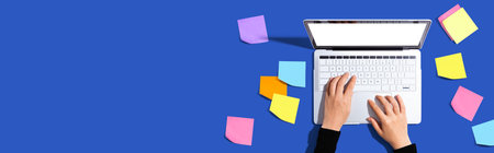 Laptop computer with many sticky notesの写真素材