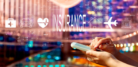 Insurance concept with person using a smartphone in city at nightの写真素材