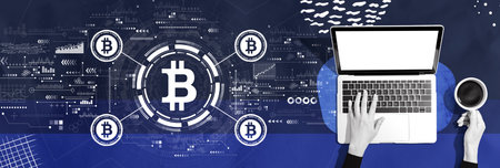 Bitcoin theme with person using a laptopの写真素材