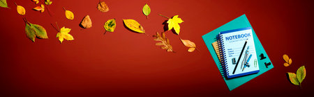 Notebooks with school supplies and autumn leavesの写真素材