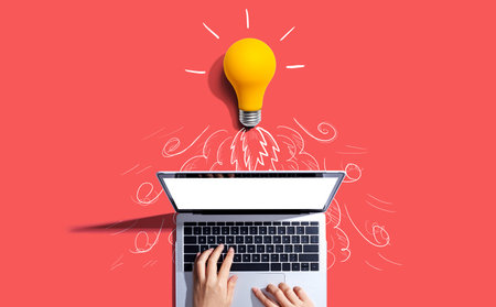 Idea light bulb flying to the sky like a rocket from a laptop computerの写真素材