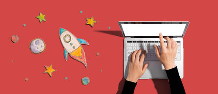 Space exploration theme with rocket and laptopの写真素材