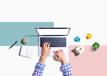 Laptop computer with a piggy bank and office objectsの写真素材