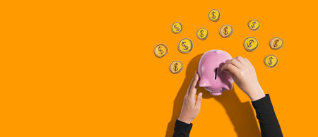 Person depositing money in a piggy bankの写真素材
