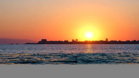 Sunset over the sea. Panoramic view of the city and the sea.
