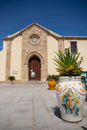 The vase with characteristic painting to Sicily in square of Marzamemi, Sicily with church in the background. Marzamemi is small town.の写真素材