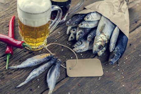 Dry fish on wooden background with beer, copy spaceの写真素材
