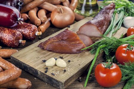 Meat. Sausages, slicing carpaccio, on a wooden table, meat products,  tomato with herbs, onions and spices, meat still lifeの写真素材
