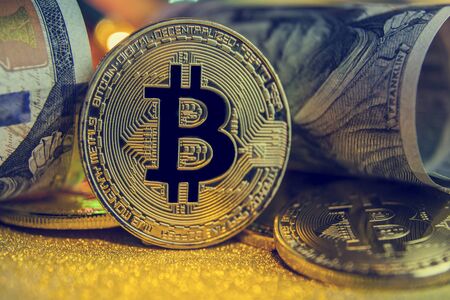 bitcoin of the black background,  on Golden nugget gold background. Finance concept; toned