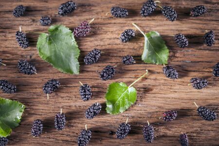 Fresh black mulberry with leaves on the wooden background, selective focusの写真素材