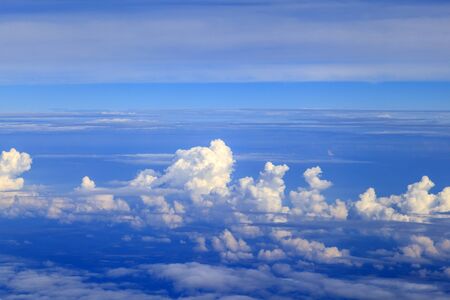 Beautiful clouds in the blue sky, the sun behind the cloud, a thunder cloud, View of the clouds from the airplaneの写真素材