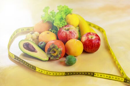 Concept of diet. Vegetables and fruits: Aavakado, figs, feijoa, cleansing the body, healthy eating, waist measuring tapeの写真素材