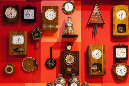 Russia, Kamensk-Shakhtinsky - October 13, 2017: museum of the USSR,  many wall clocks on a red wall, Free open.のeditorial素材
