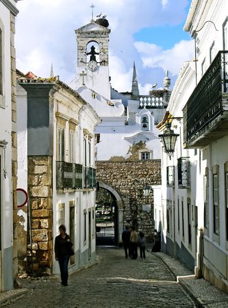 Well known entrance arc with storks on the bell tower, located on Faro, Portugal. の写真素材