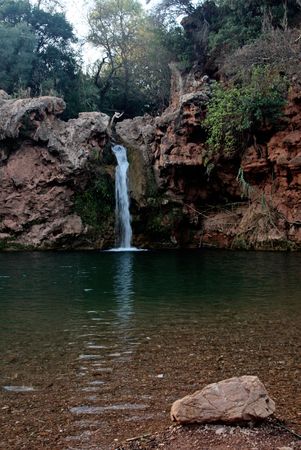 Small waterfall lake with plenty of vegetation on the back.の写真素材
