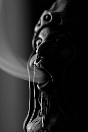 Close view of a smoking doll with smoke getting out of it's mouth.の写真素材
