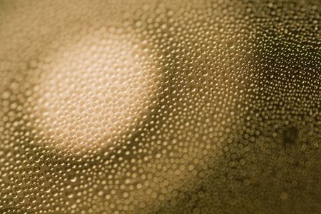 Closeup abstract of many condensated drops of water with a focus of light circle.の写真素材