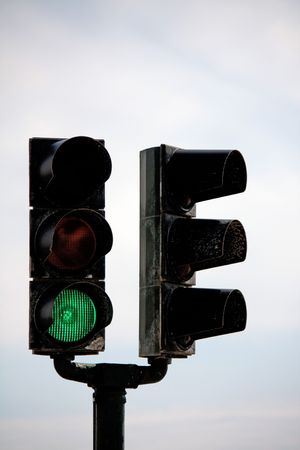 View of a double fork traffic light pole with a green light.の写真素材