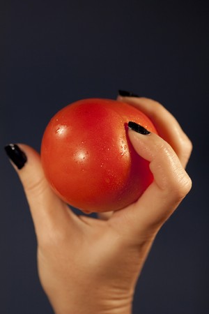 View of a woman's hand holding a red tomatoe.の写真素材