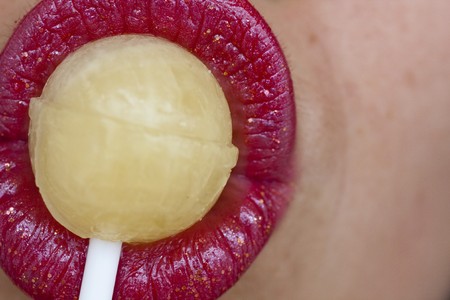 Close up view of some red lips with a lollipop.の写真素材
