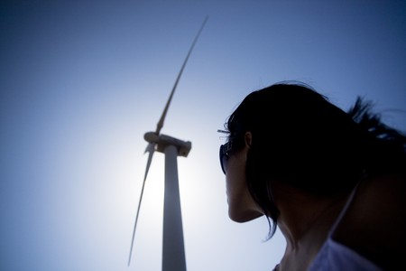 View of a young girl watching a windmill.の写真素材