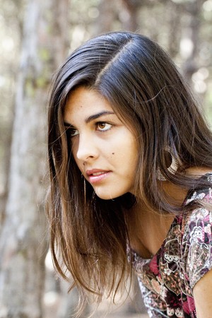 Beautiful girl with floral dress posing on a forest.の写真素材