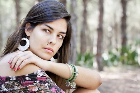 Beautiful girl with floral dress posing on a forest.の写真素材