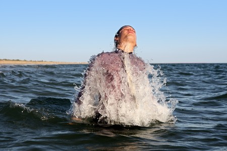 business man burst from the deep sea making splash of water.