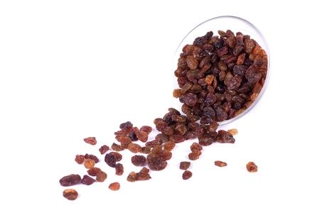 Close view of a pile of dry raisins on a bowl isolated on a white background.の写真素材