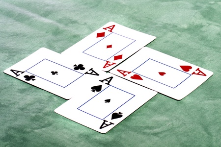 Close up view of a set of four aces spread on a green cloth table.の写真素材