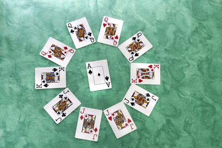 Close up view of a circle of playing cards spread on a green cloth table.のeditorial素材