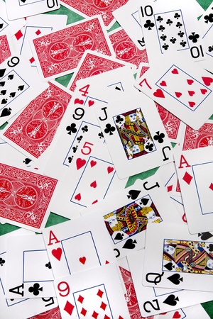 Close up view of a bunch of playing cards spread on a green cloth table.のeditorial素材