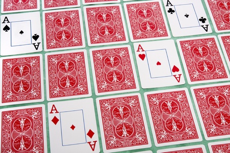 Close up view of a bunch of flipped playing cards spread on a green cloth table.