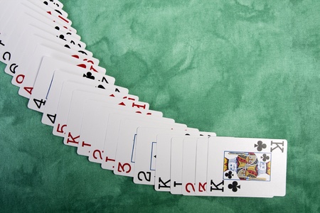 Close up view of a bunch cards spread on a green cloth table.のeditorial素材