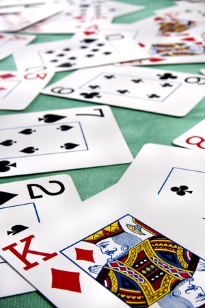 Close up view of a bunch cards spread on a green cloth table.のeditorial素材