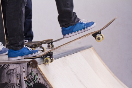 View of a bunch of skaters with skate boards on a pipe.