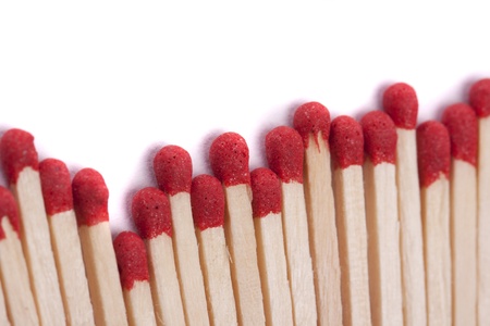 Close up view of a bunch of matches with red heads on a white background.の写真素材