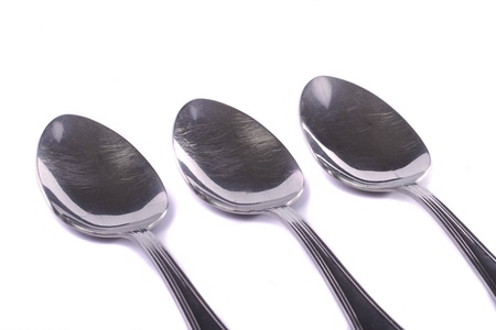 Close up view detail of some spoons isolated on a white background.の写真素材