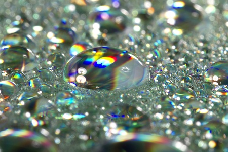 Close up view of many colorful and bright drops of water on a shiny surface.の写真素材