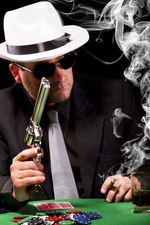 View of a gangster man playing some cards and poker, smoking a Cuban cigar.のeditorial素材