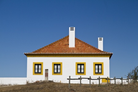 View of a traditional white with clay tile roof and chimney house in the Algarve region, Portugal. のeditorial素材